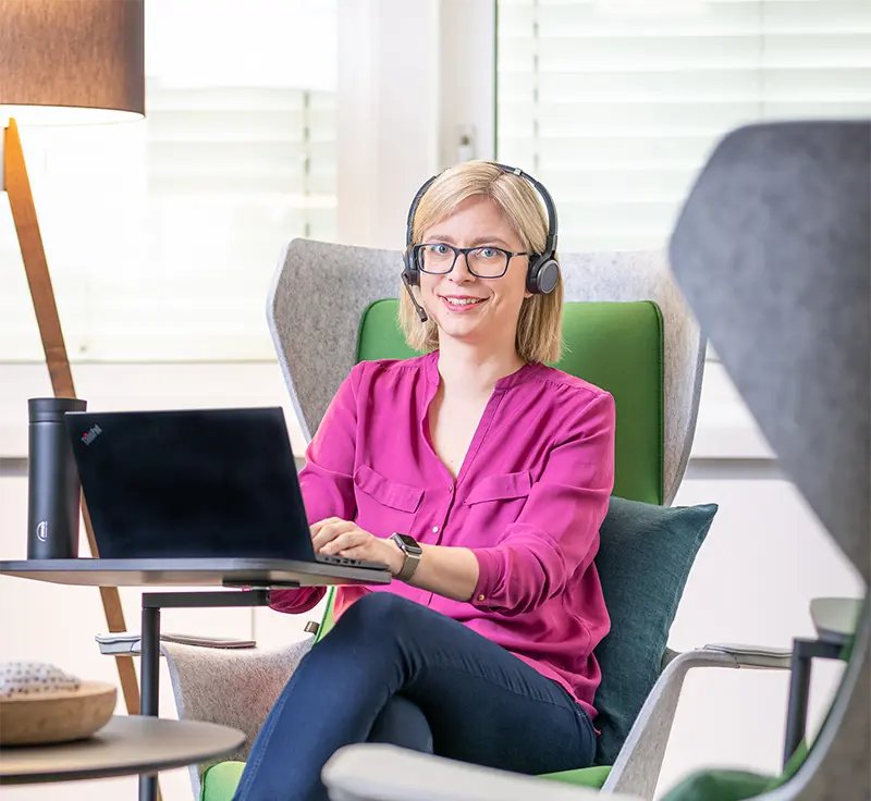 Frau am Laptop mit Headset Office Thinkpad Thermobecher AWADO Kommunikation